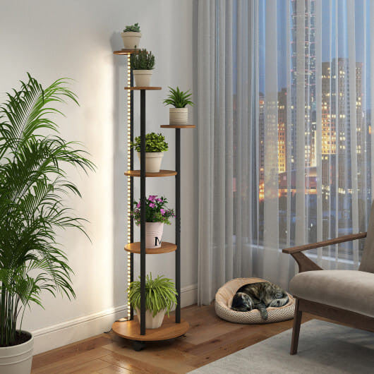 Tall wooden plant stand with plants in a room with a cityscape view.