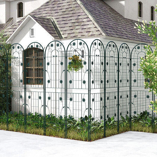 Decorative metal fence in front of a white building with a gray roof.