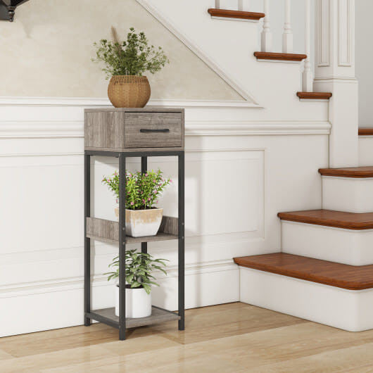 Small wooden side table with planters against a staircase in a home setting