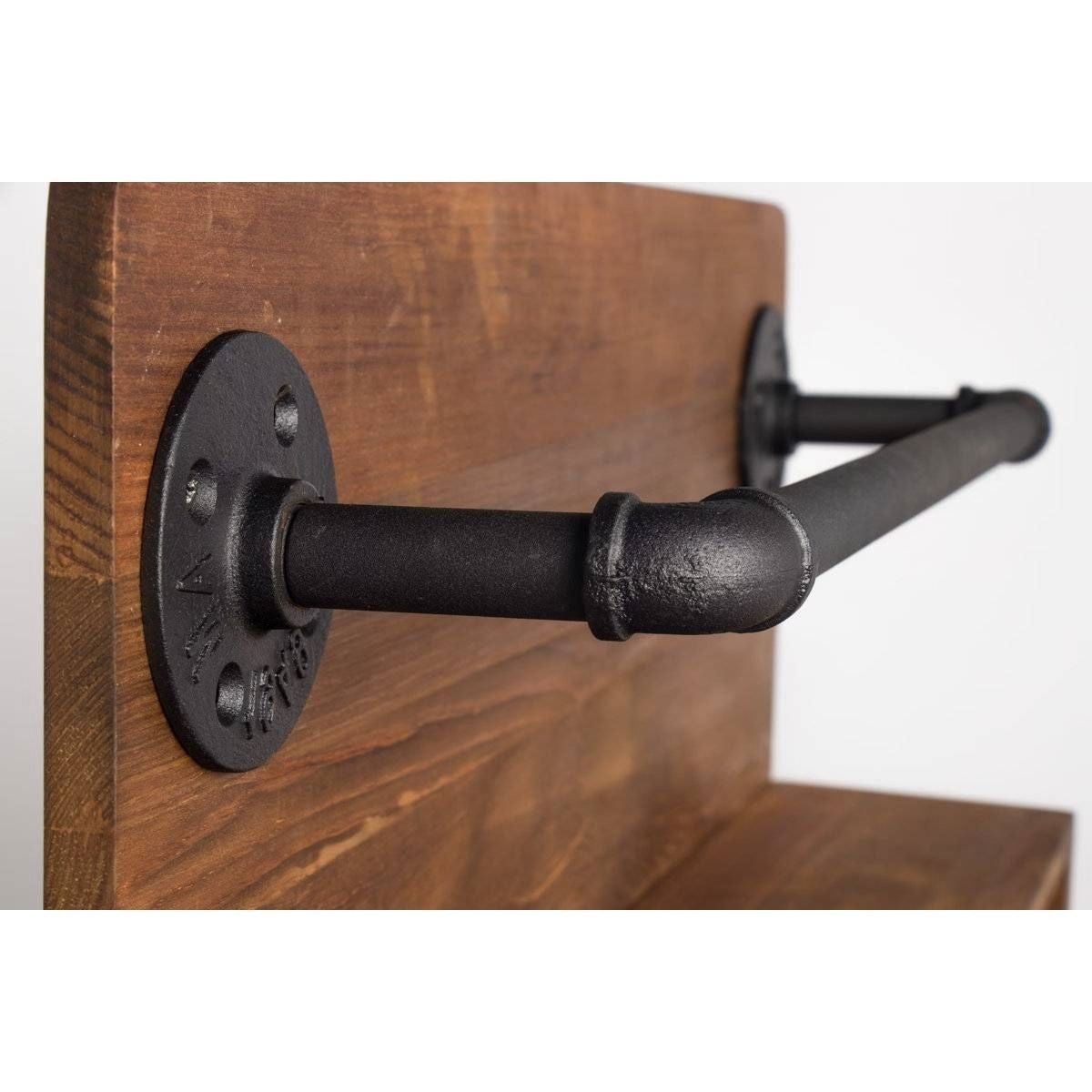 Black metal pipe bracket on a wooden surface