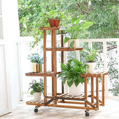 Wooden plant stand with multiple shelves holding various potted plants in a bright indoor setting.