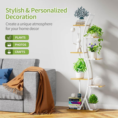 White circular shelf with plants, books, and decor items against a gray wall.