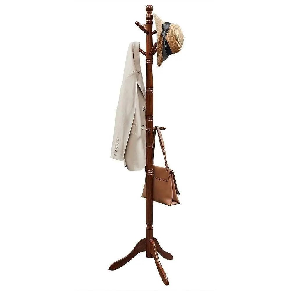 Wooden coat rack with a beige coat, brown bag, and straw hat on a white background