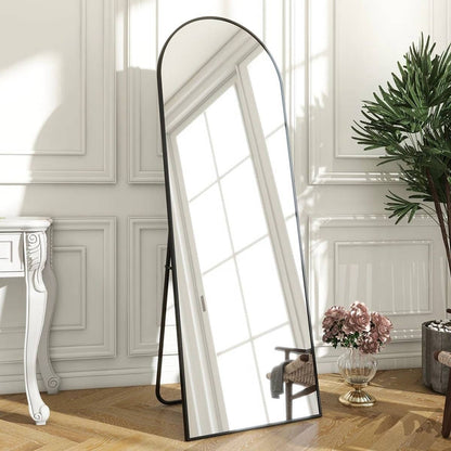 Full-length mirror in a room with white walls and wooden floor.
