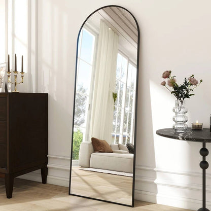Full-length mirror in a room with a couch, table, and decorative items.