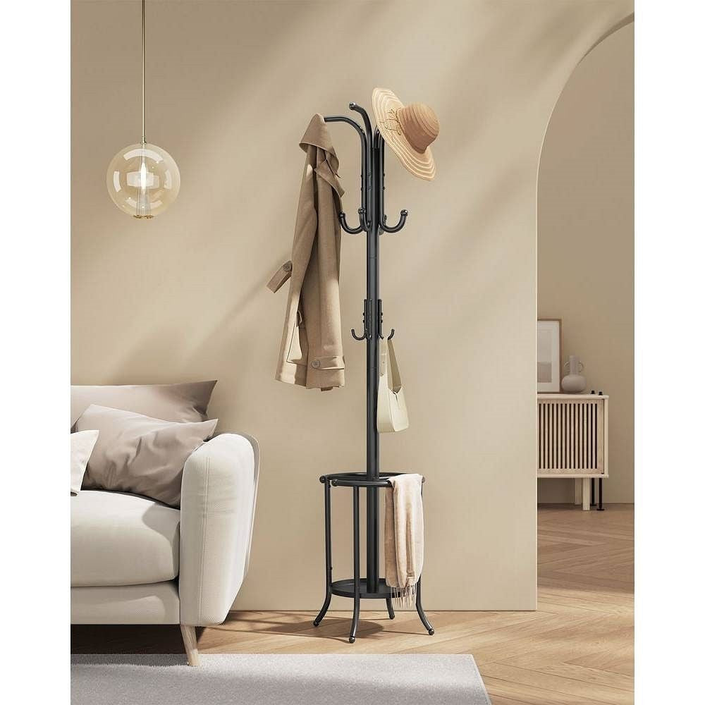 Black coat rack with a hat and coats in a living room setting.