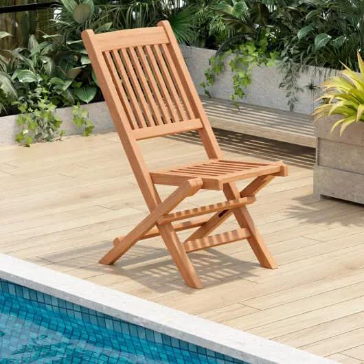 Wooden folding chair on a wooden deck by a pool with plants in the background