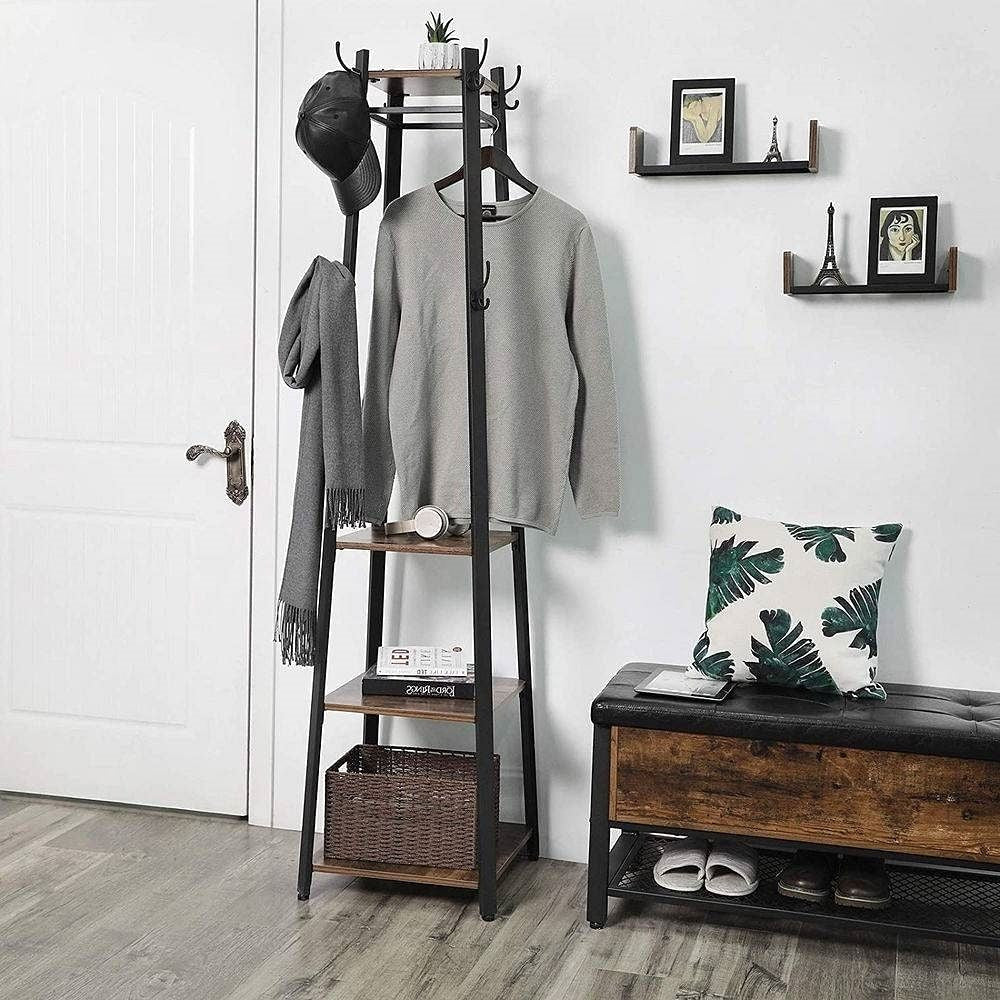 Entryway with a coat rack, bench, and shelves against a white wall.