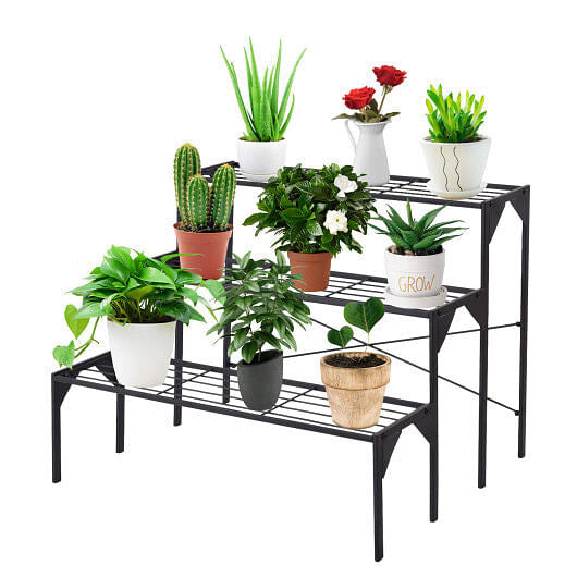 Black metal plant stand with various potted plants on a white background