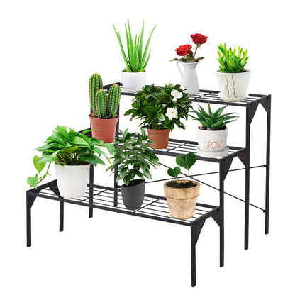 Black metal plant stand with various potted plants on a white background