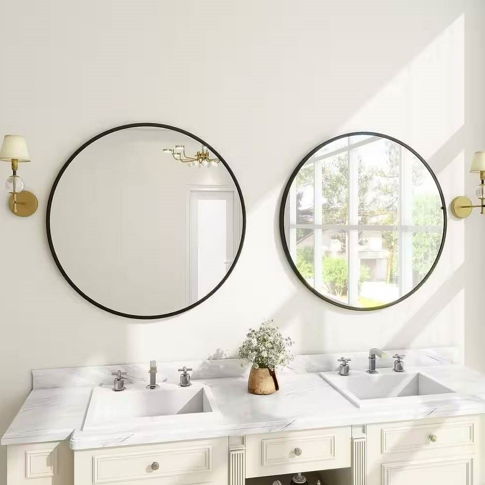 Bathroom vanity with two round mirrors, lights, and a window.