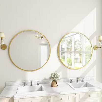 Bathroom with two round gold-framed mirrors above white sinks.