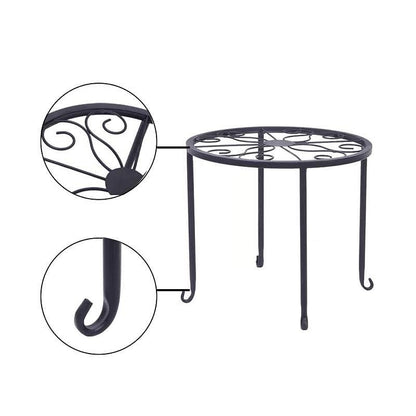 Black metal round table with decorative legs on a white background