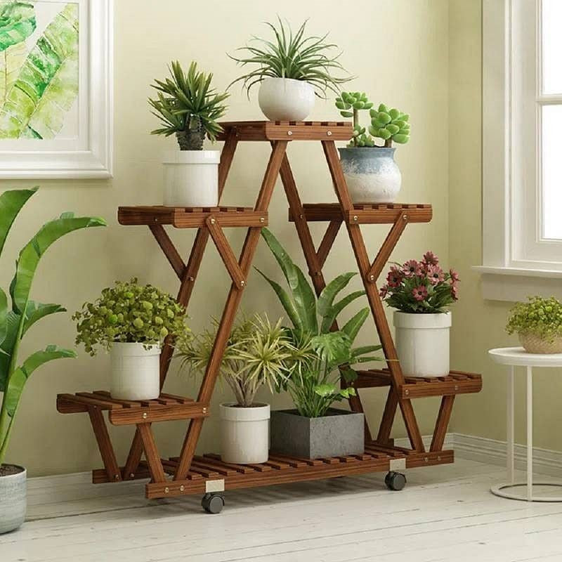 Wooden plant stand with multiple potted plants in a room setting.