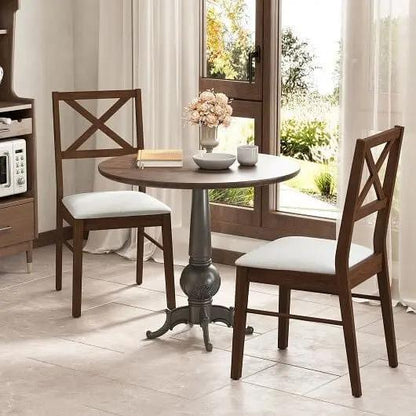 Dining area with wooden table and chairs in a bright room with large windows.