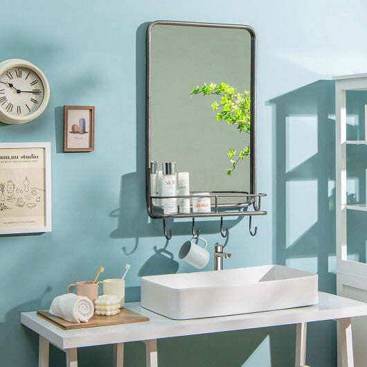 Bathroom setup with a mirror, sink, and various items on a blue wall.
