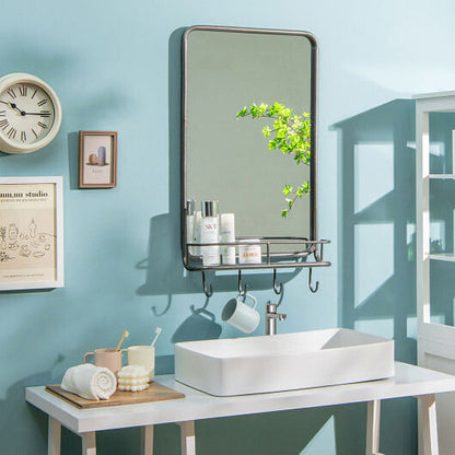 Bathroom setup with a mirror, sink, and various items on a blue wall.