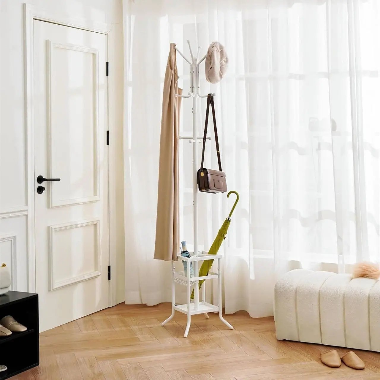 White coat rack with various items against a neutral background